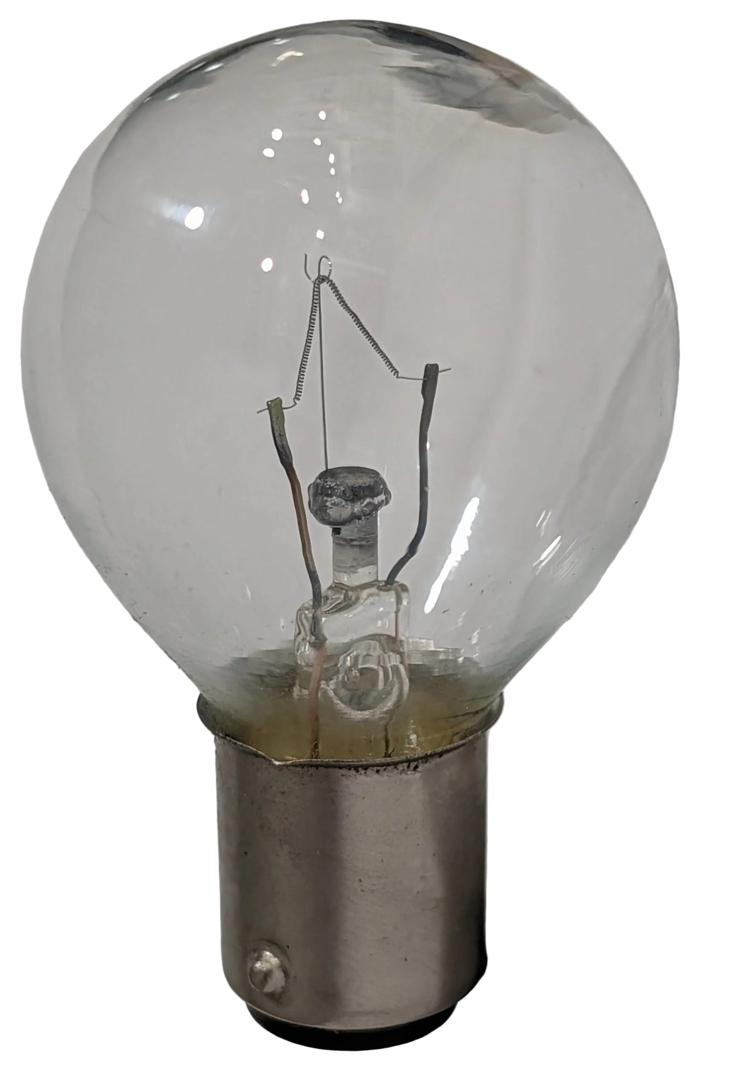 A clear glass light bulb with a silver metal bayonet base, showing the internal filament structure against a plain light background.